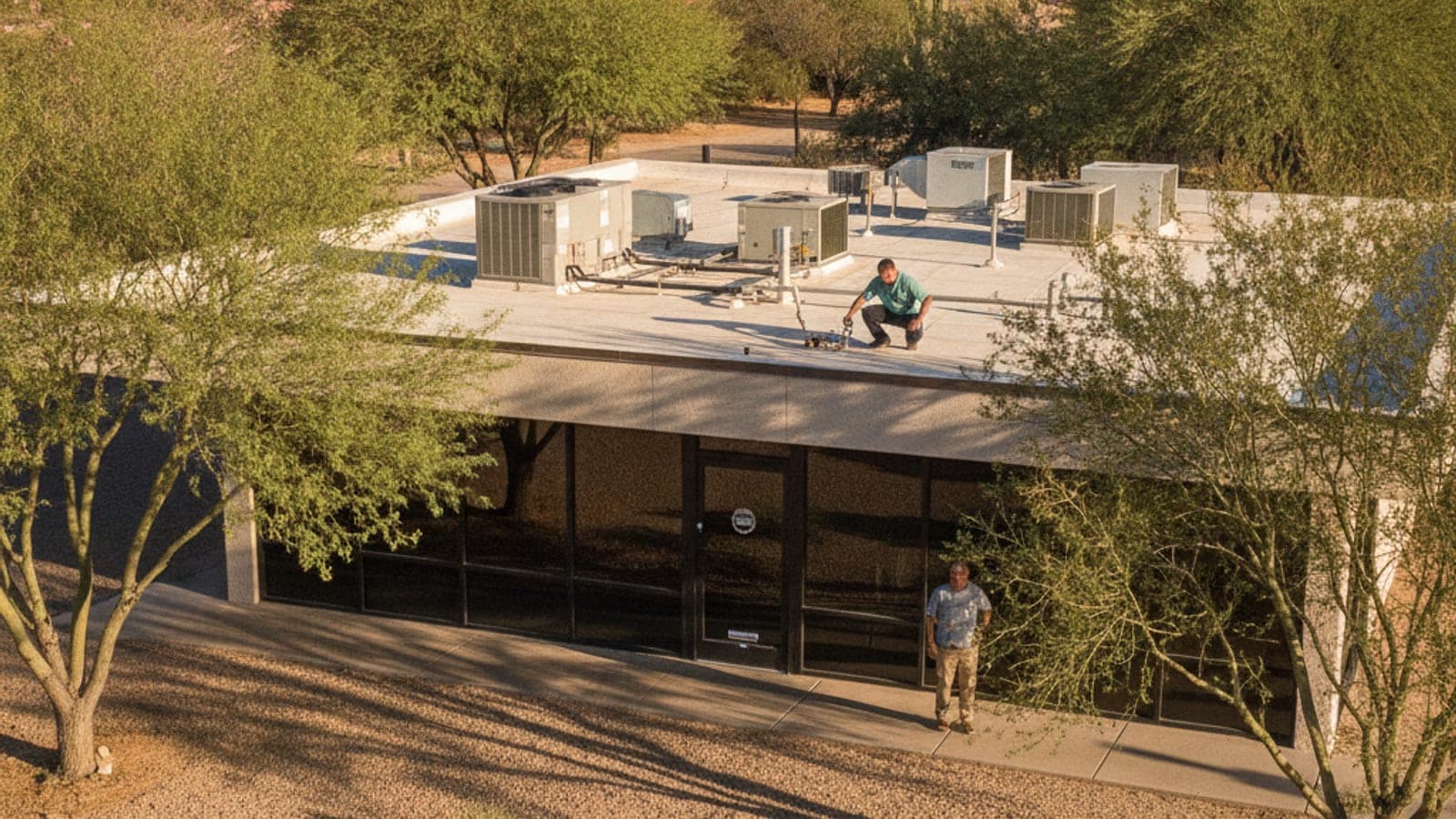 Small retail strip building in Tucson with a glass storefront and rooftop HVAC units on a flat roof under desert sun