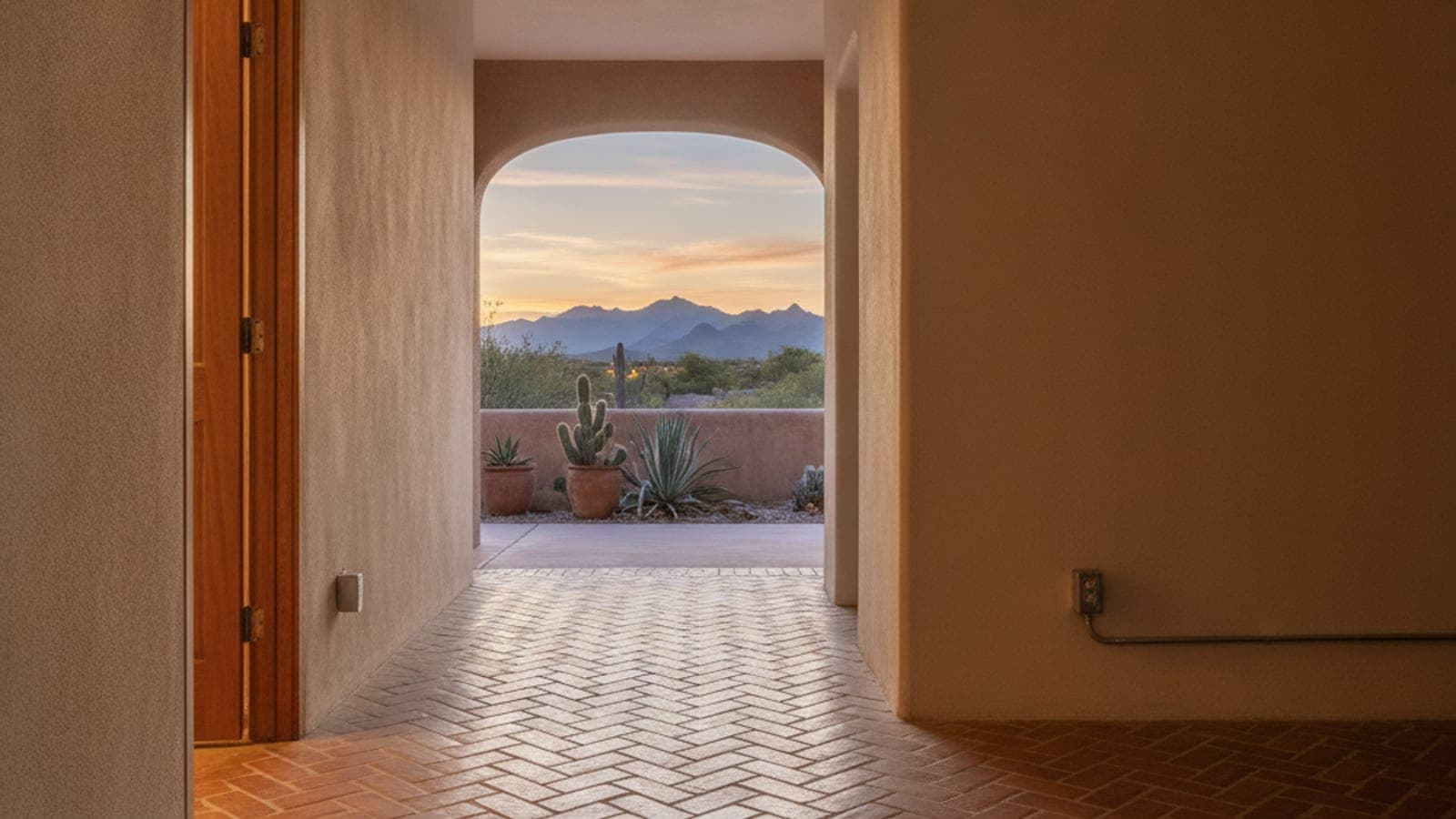 Floor vent register in a Tucson home with terracotta tile and a casita door in the background