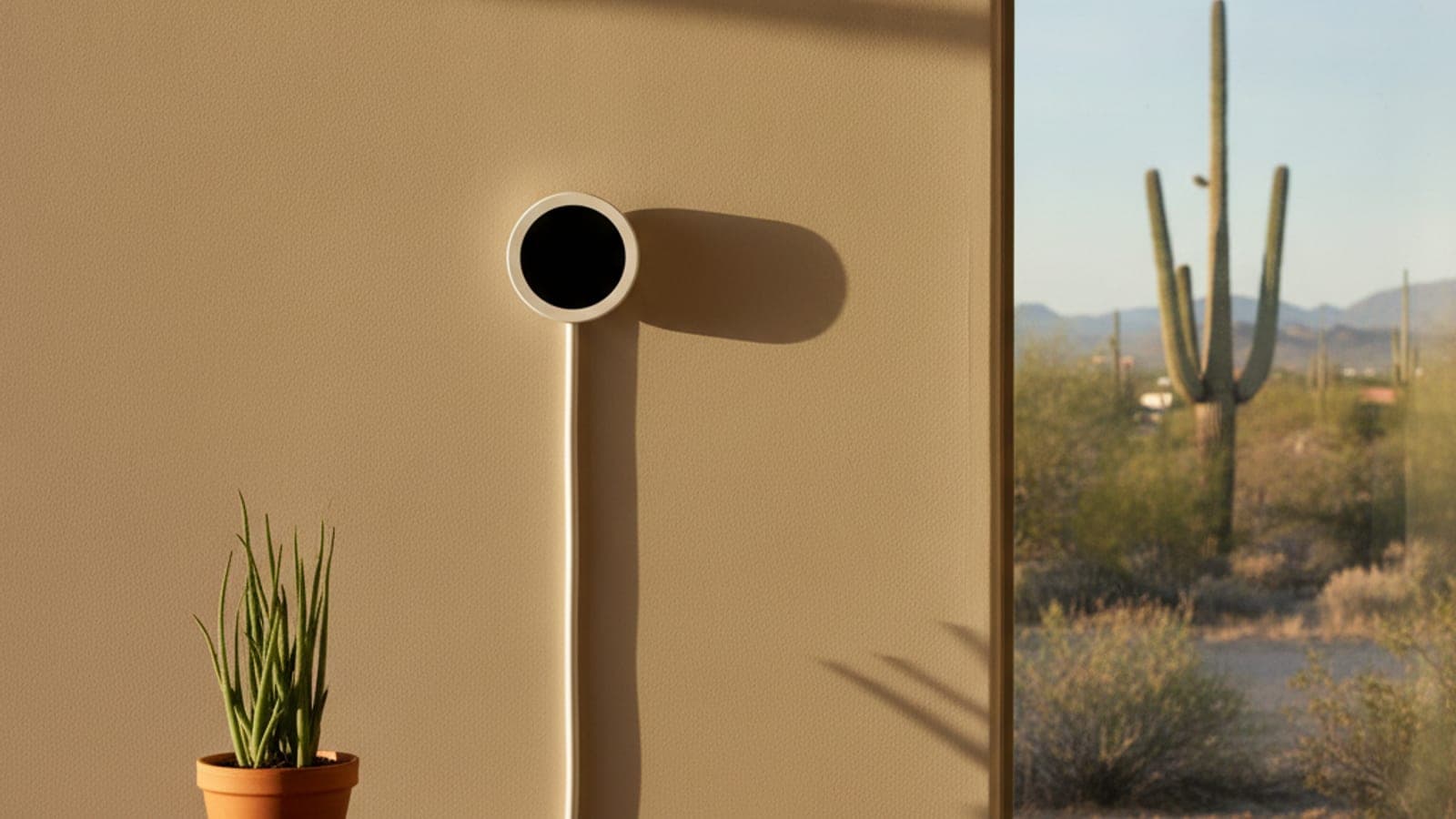 Smart thermostat on a plaster wall in a Tucson home with warm afternoon desert light